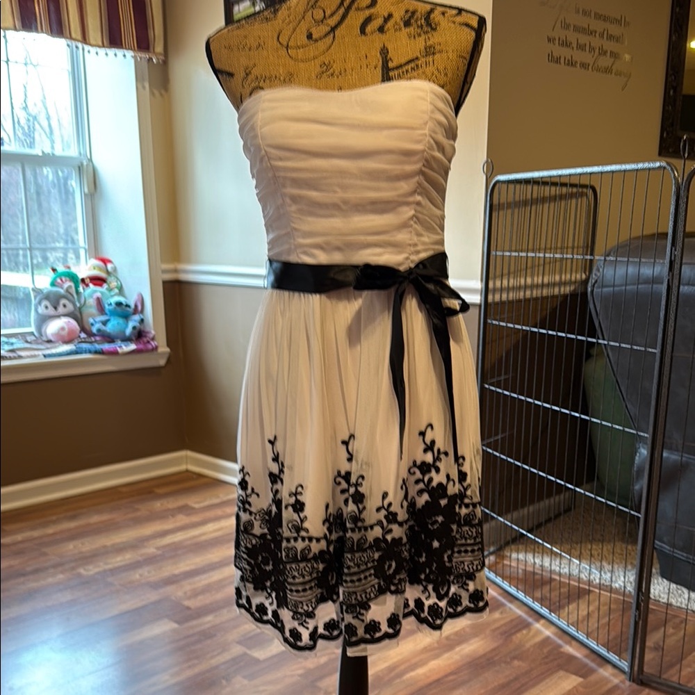 Size 11/12 white strapless dress with black satin belt and black designs